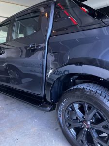 "Side view of a black SUV showing a mirror-like glossy finish after Fireball Ceramic Coating application."